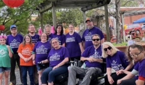 A group of Arc Northeast Mississippi members and supporters wearing purple shirts at a community event
